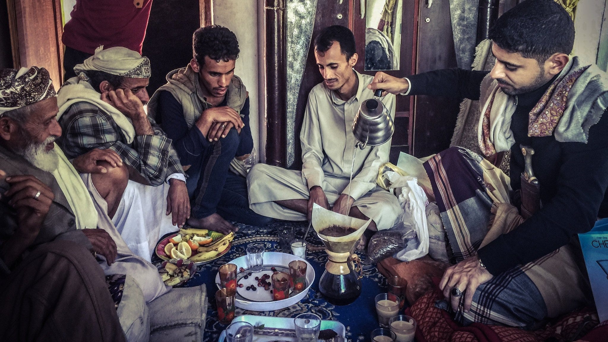 Mokhtar Alkhanshali pouring coffee in a traditional gathering in Yemen.